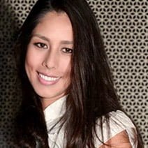 Sobre Sites&Cia 20 Mulher sorrindo, de cabelos escuros e compridos a frente do ombro.